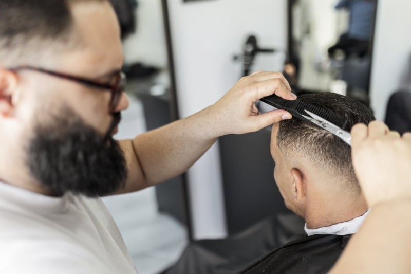 barber cutting hair with scissors