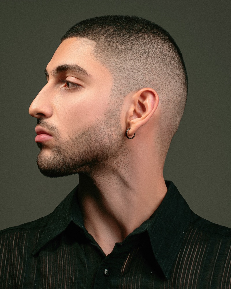 Man with a 3 guard buzz cut and faded sides viewed in profile