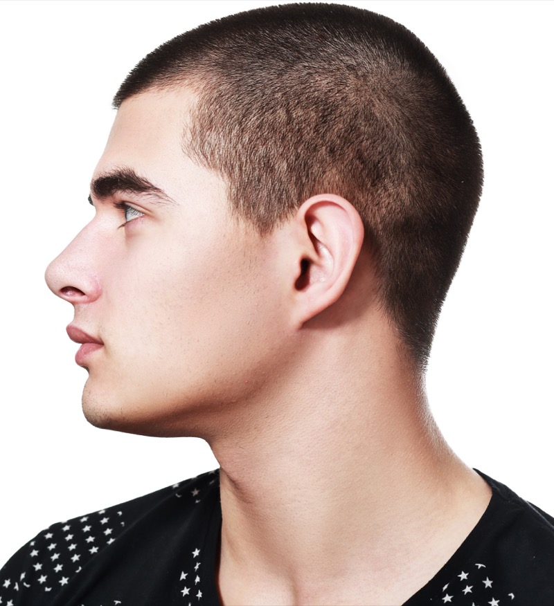 Man with a 3 guard buzz cut viewed from the side