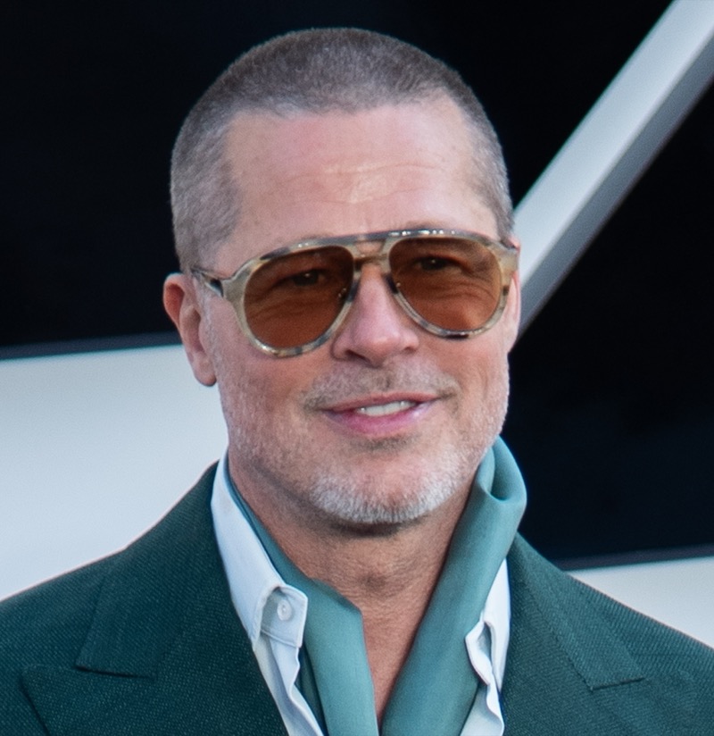 Brad Pitt with a close buzz cut and amber aviator sunglasses in 2025