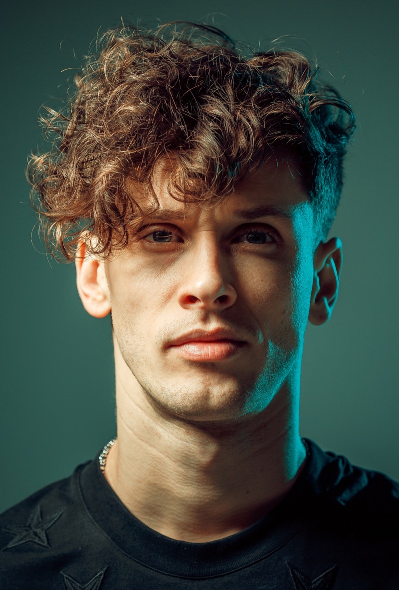 Man with a curly undercut and a long curly fringe
