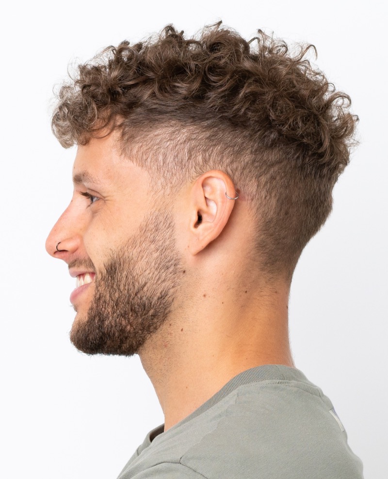 Man with a curly undercut and short curls viewed from the side